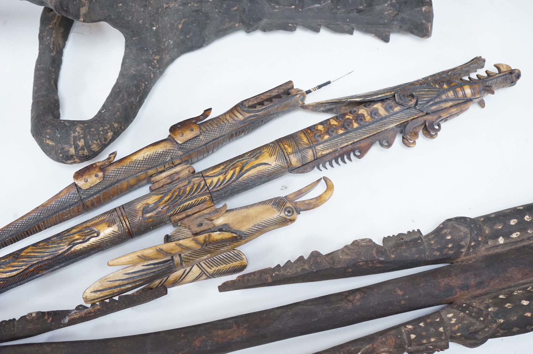 Two Papua New Guinea Sepik River carvings and a carved bone artefact, largest 92cm in length